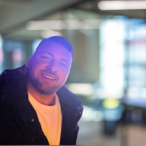 Emil, owner of Aylesbury Exterior Cleaning, smiling towards the camera in a modern indoor setting